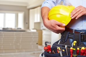 Home renovations with contractor in hardhat and construction materials.