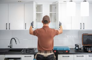 Contractor installing cabinets during a kitchen remodel.