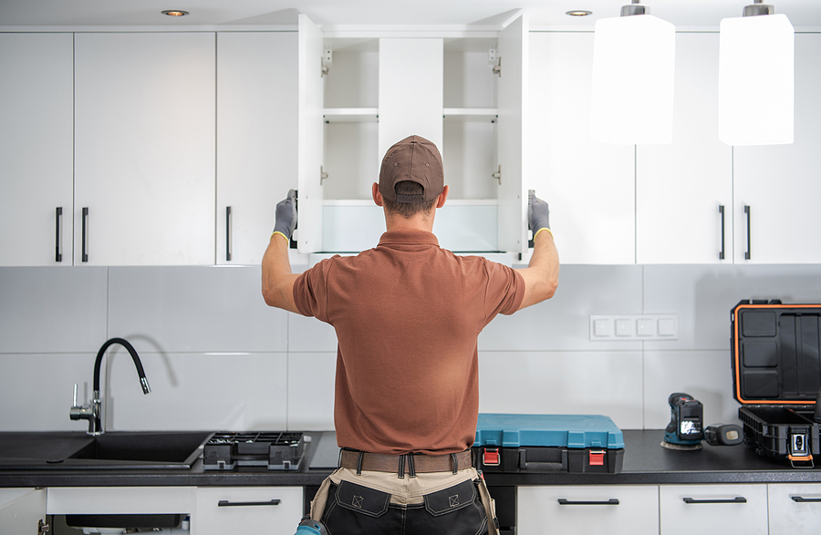 Contractor installing cabinets during a kitchen remodel.