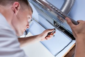 Contractor installing a new kitchen range hood.